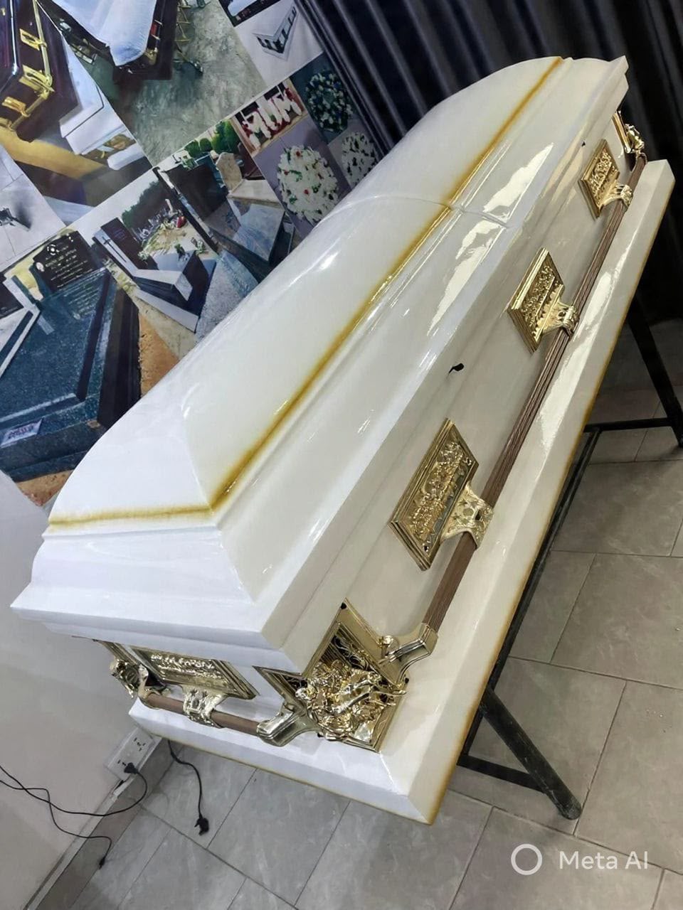 White casket with ornate gold-tone hardware and gold trim
