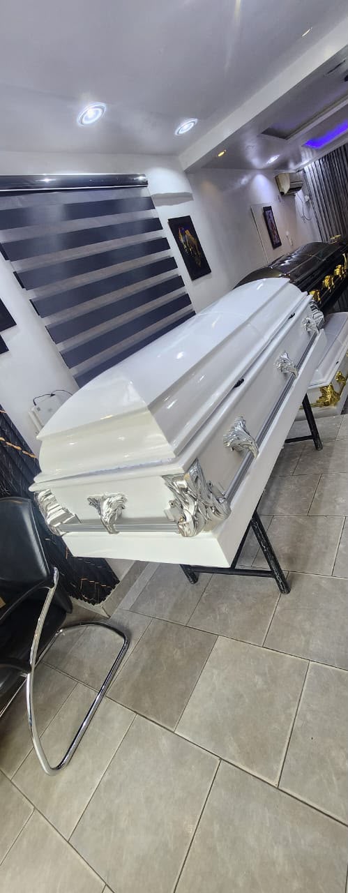 White casket with polished silver-tone handles and sculpted details