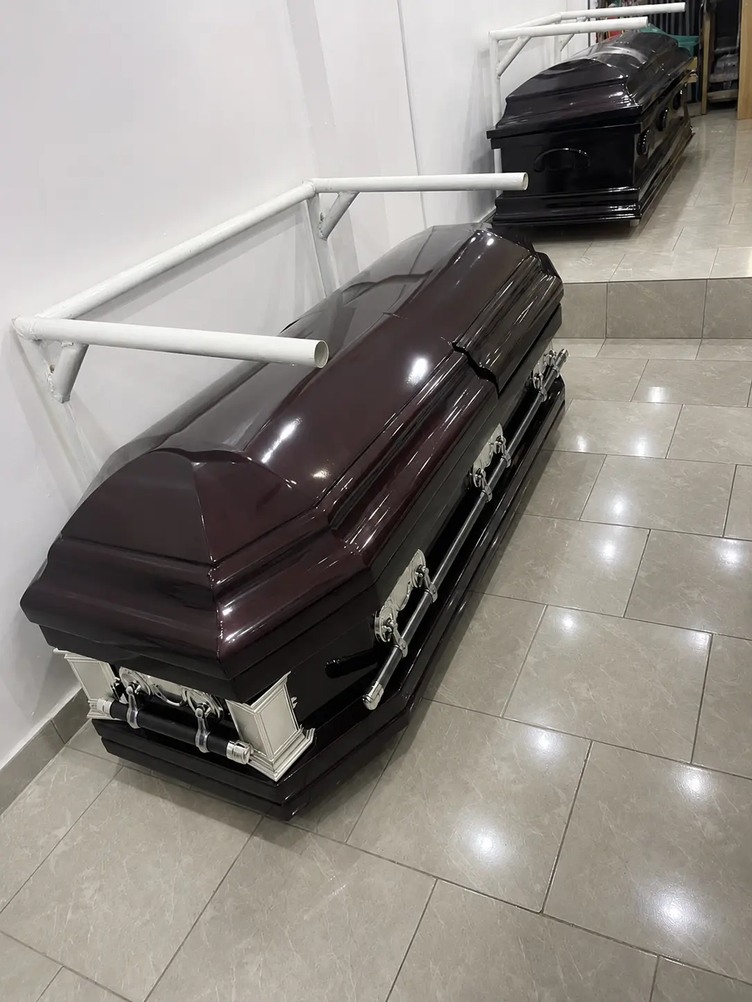 Deep burgundy mahogany casket with silver corner plaques and chrome handles