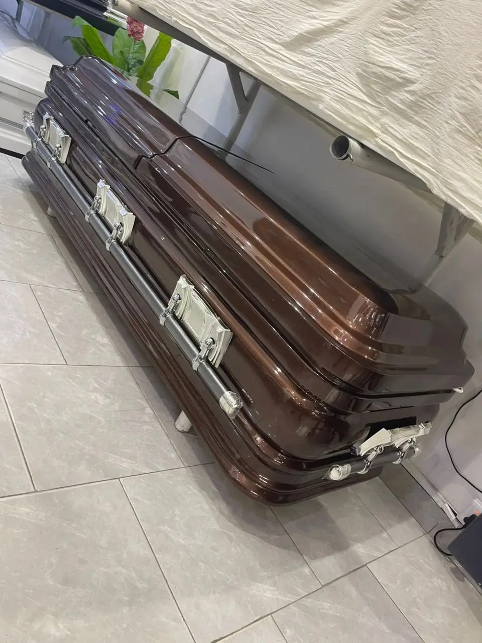 Dark wood-finish casket with silver-tone handles in the showroom