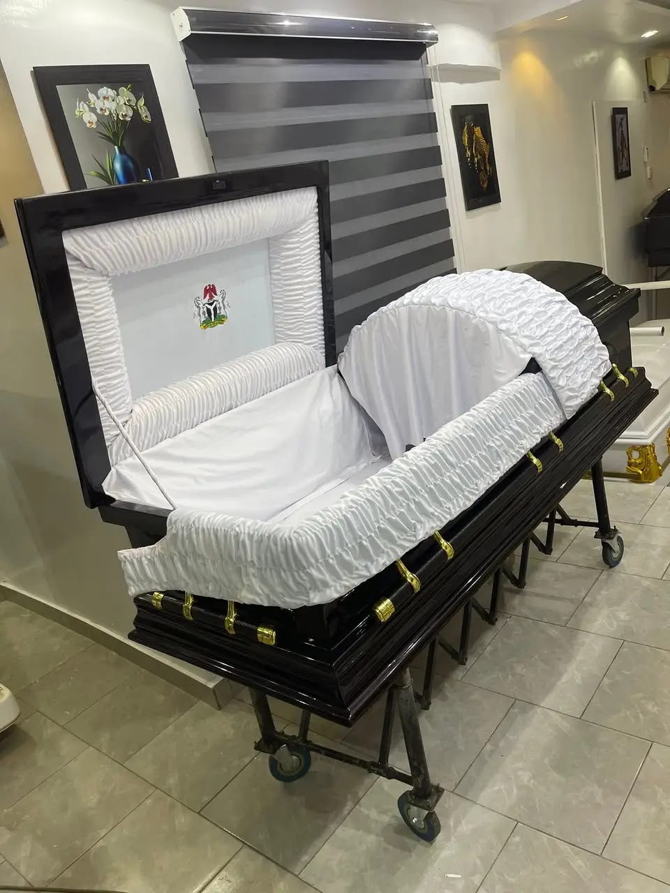 Open dark wood casket with a white ruched interior in the showroom