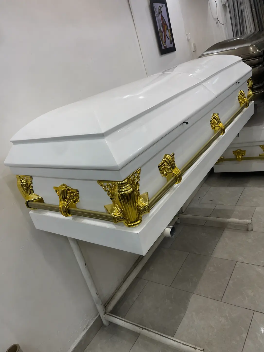 Luxury white high-gloss casket with ornate 24-carat gold hardware and full-length gold bar handles